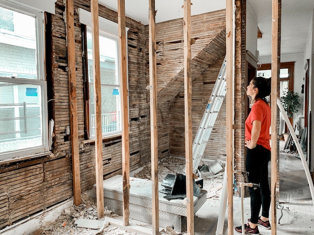 a person looking at an exposed wall during a room renovation